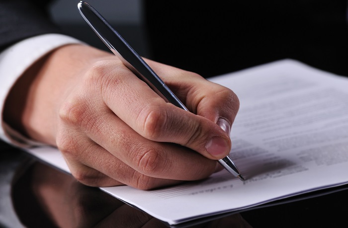 businessman writing on a form