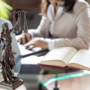 Lawyer office. Statue of Justice with scales and lawyer working on a laptop. Legal law, advice and justice concept