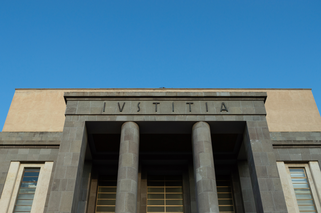 Word latin IUSTITIA in front of a tribunal facade, Justice in latin